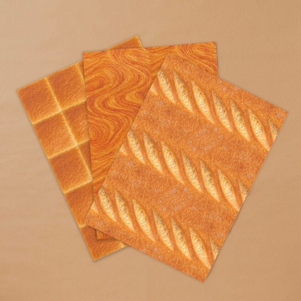 three sheets of wrapping paper with realistic bread designs