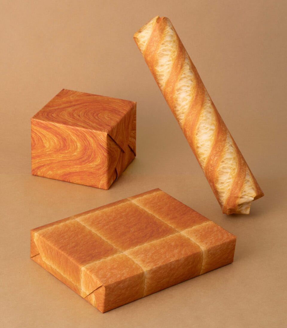 three gifts wrapped in paper with a realistic printed bread design. they resemble loaves
