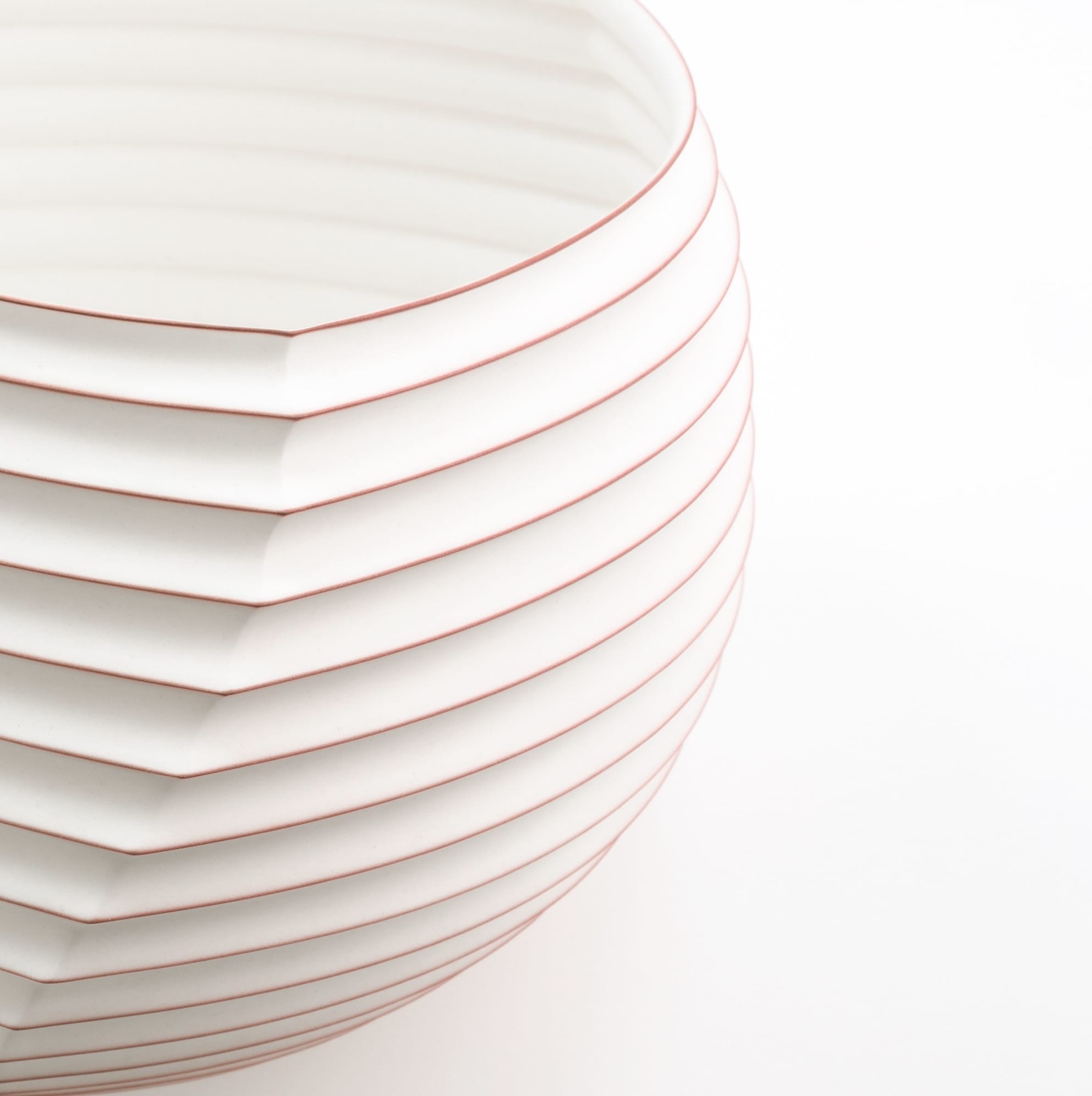 a detail of an abstract, white porcelain sculptural vessel loosely resembling intricately folded paper