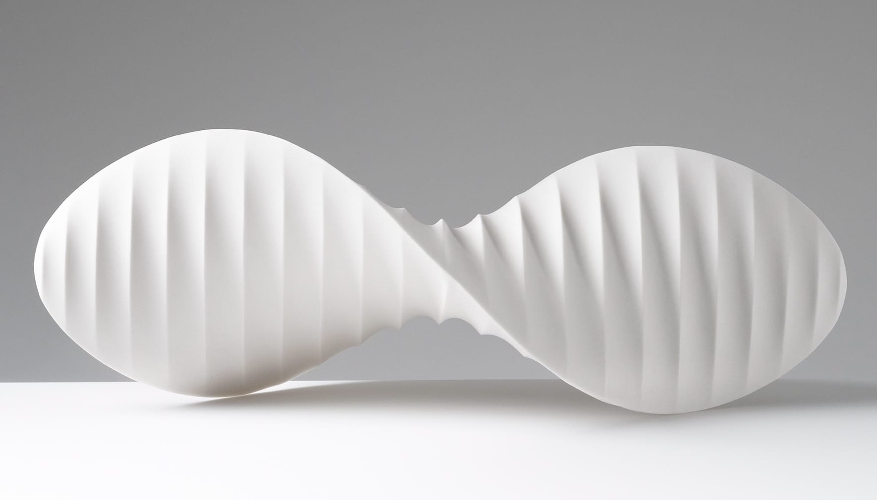 an abstract, white porcelain sculpture loosely resembling intricately folded paper