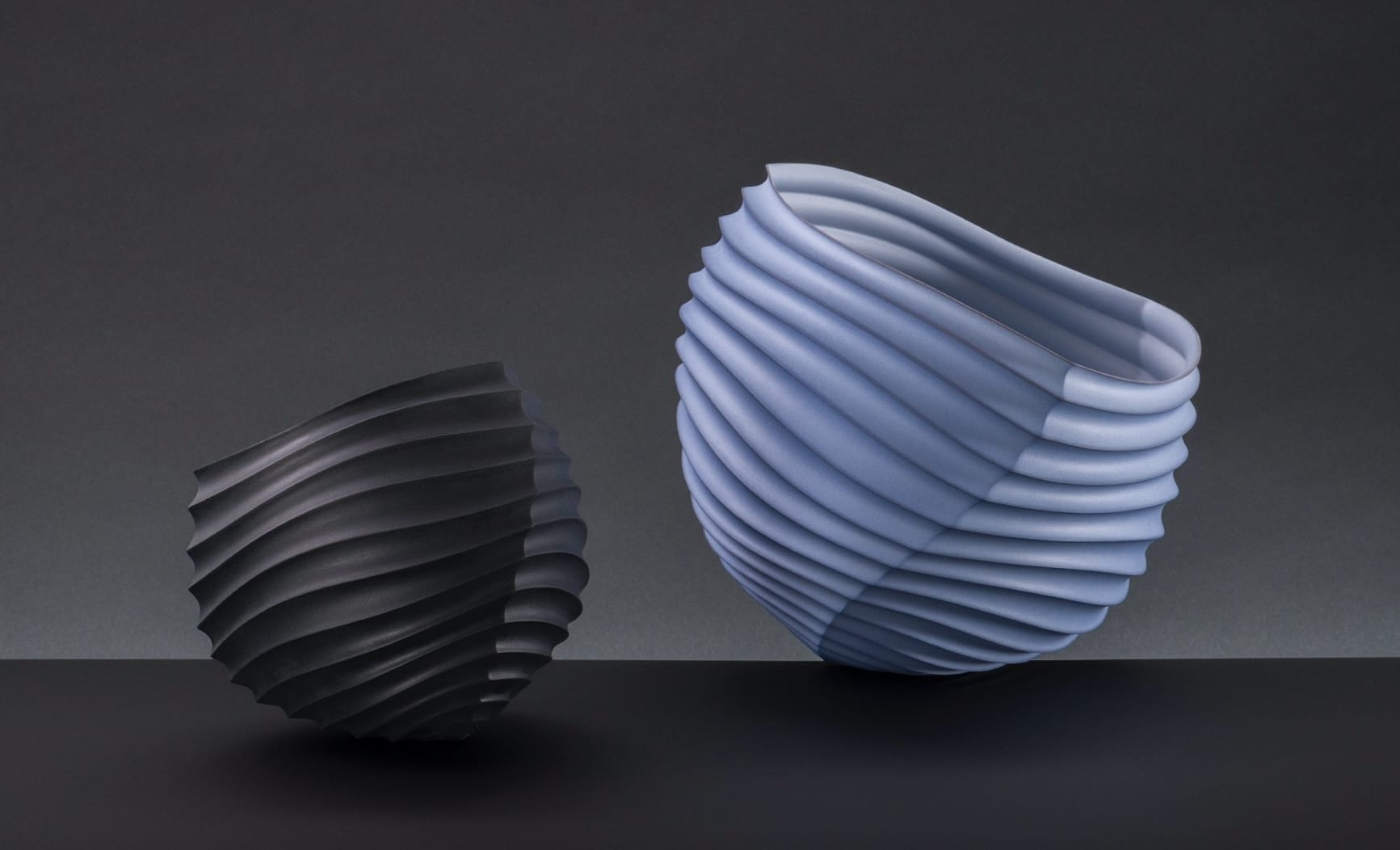two abstract porcelain sculptures loosely resembling intricately folded paper