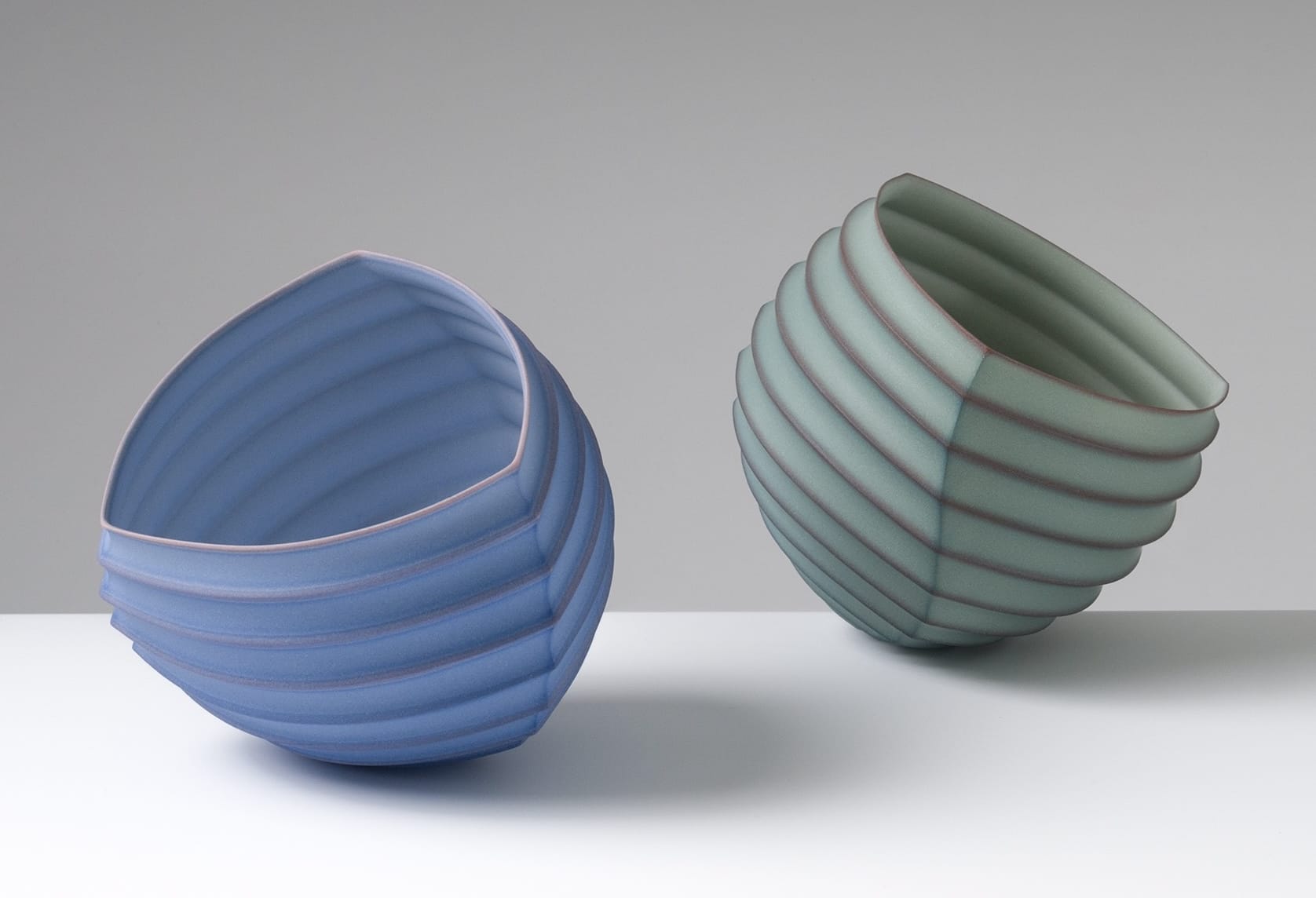 two abstract porcelain sculptures loosely resembling intricately folded paper