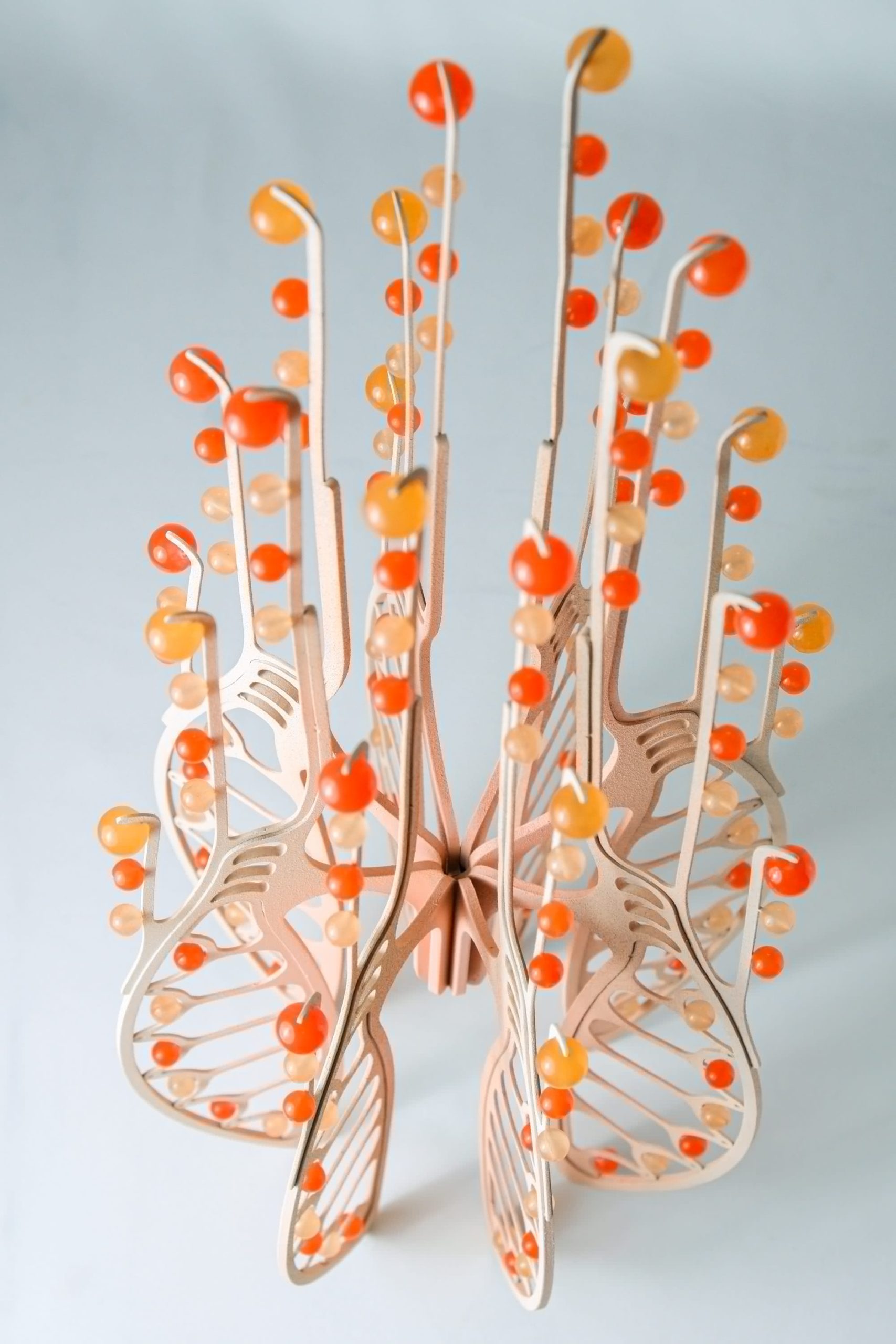 a tall orange sculpture with orange beads