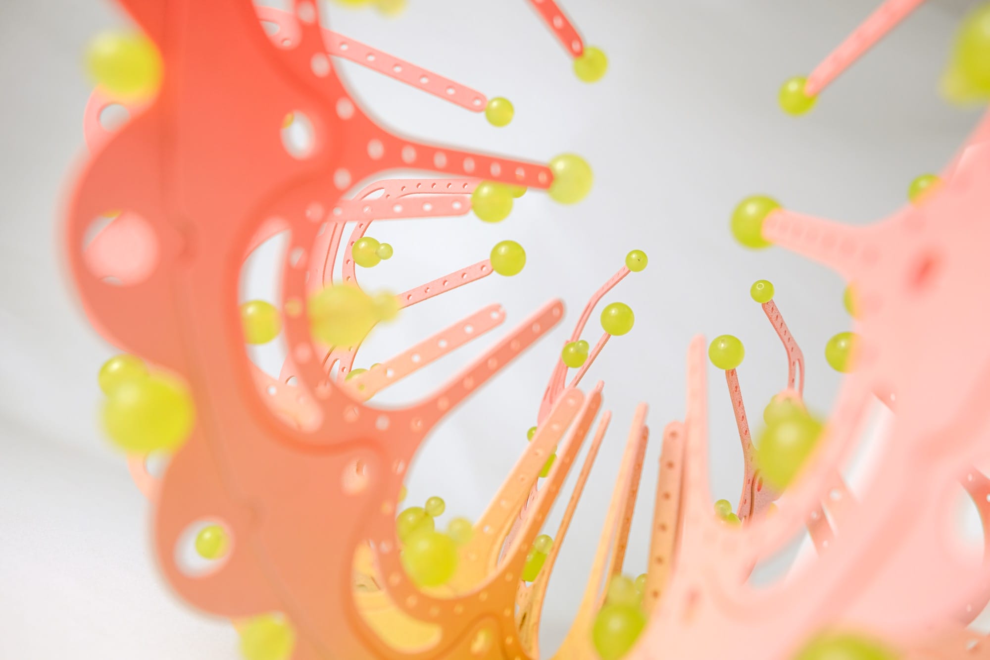 detail of a pink and yellow curved sculpture with scalloped edges