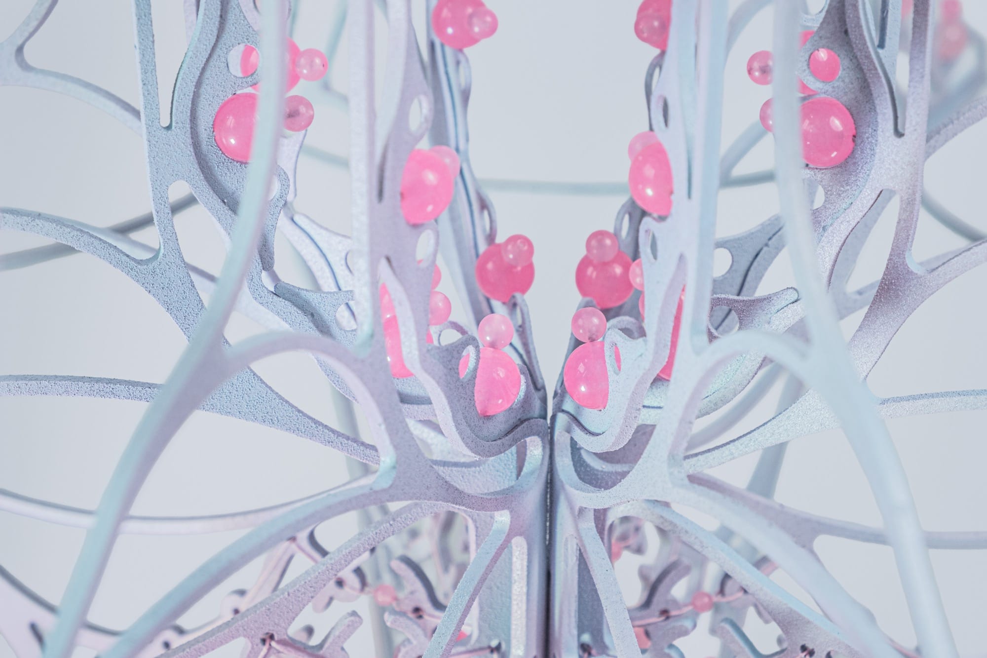 detail of a pink and purple curved sculpture with scalloped edges