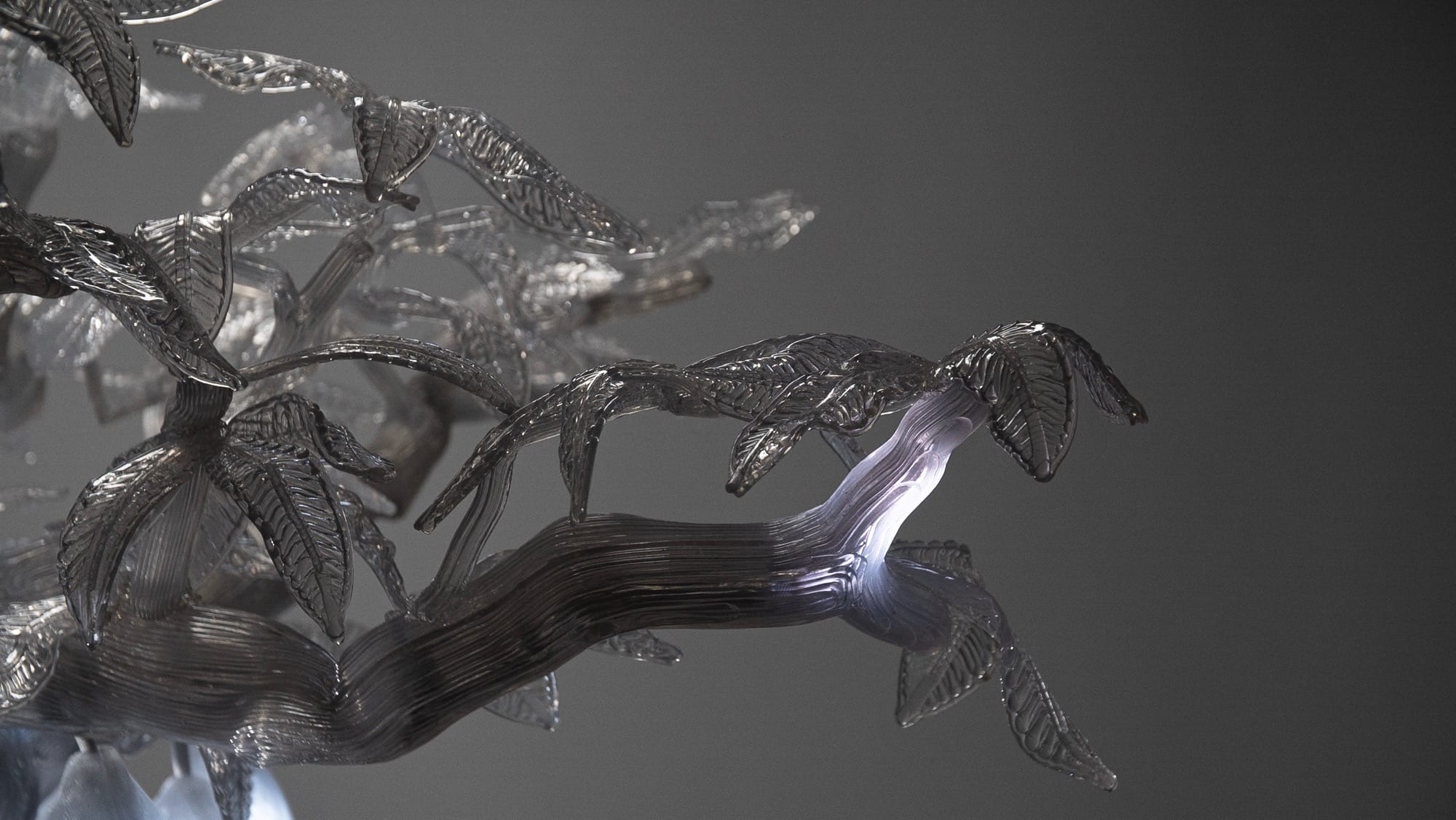 a detail of a sculpture of a clear, illuminated cacao tree