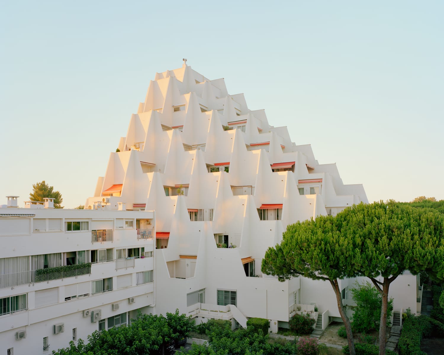 a modernist resort apartment complex in all-white against a blue sky