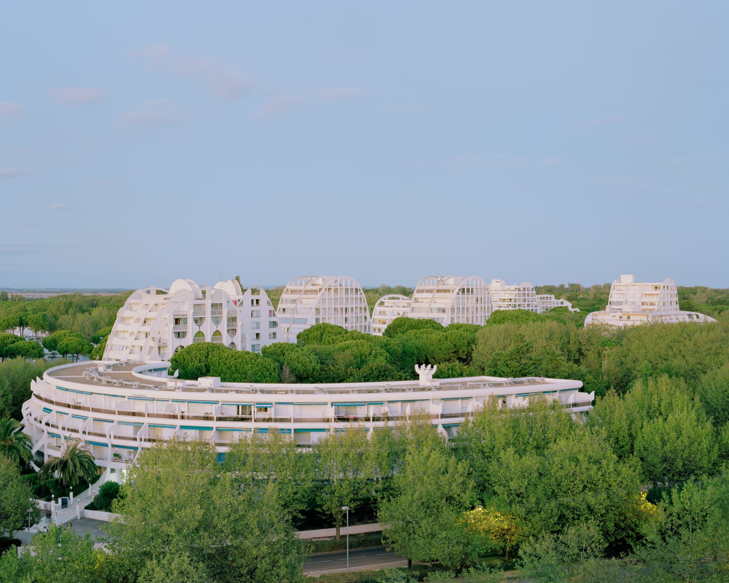 a modernist resort apartment complex in all-white against a blue sky