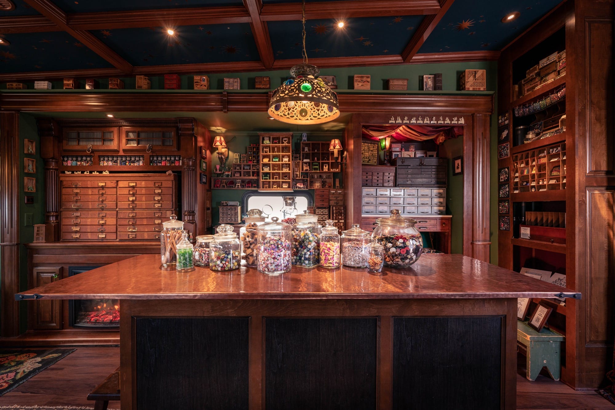 the moody wood and soft seating interior of a traveling museum with cabinets, jars, and lots of storage