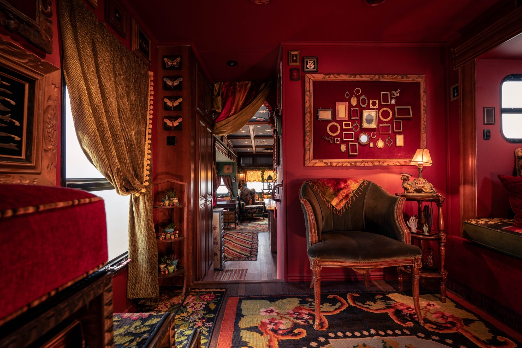 an interior with red walls, plush seating, and displays on the wall