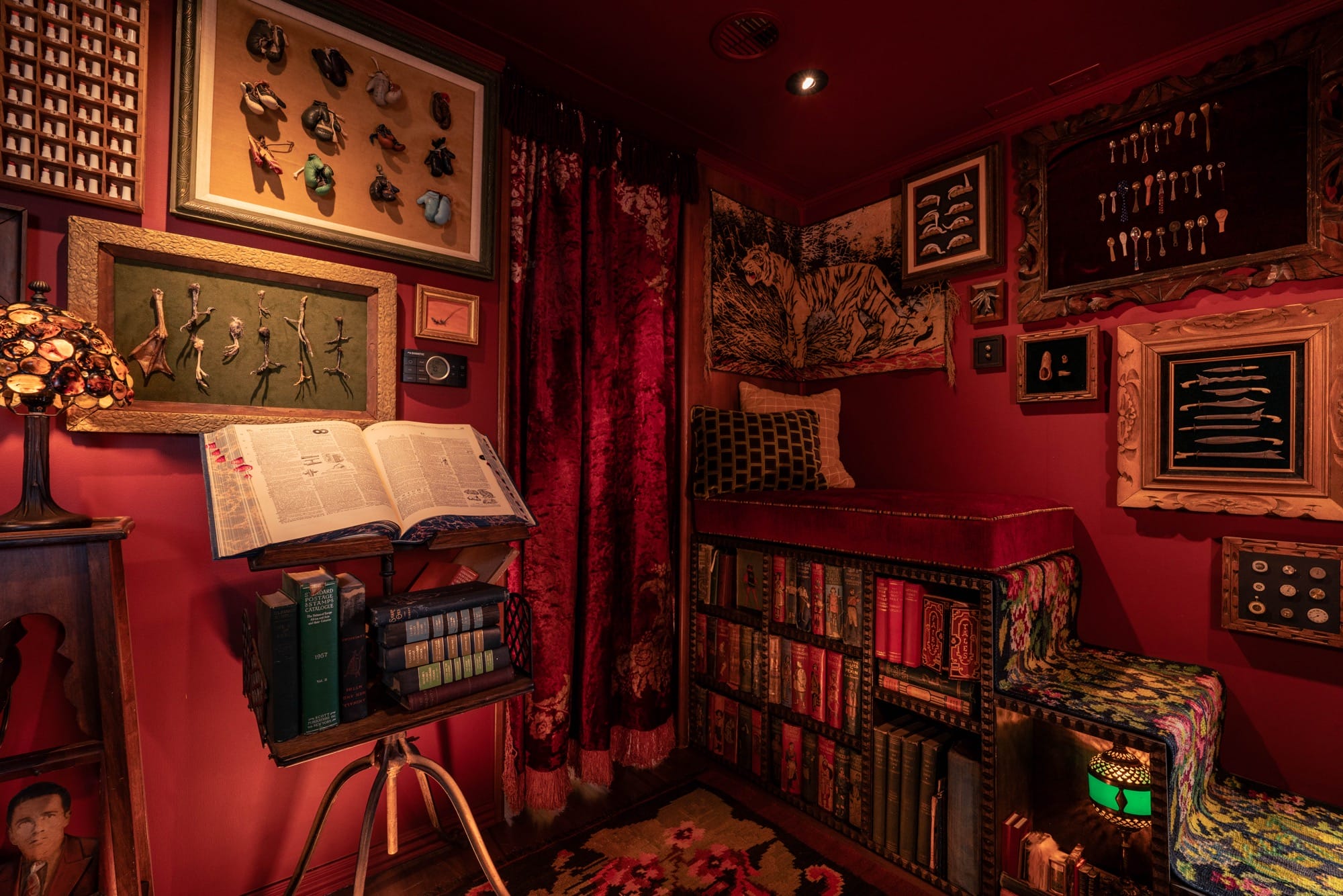 an interior with red walls, full bookcases, and displays on the wall