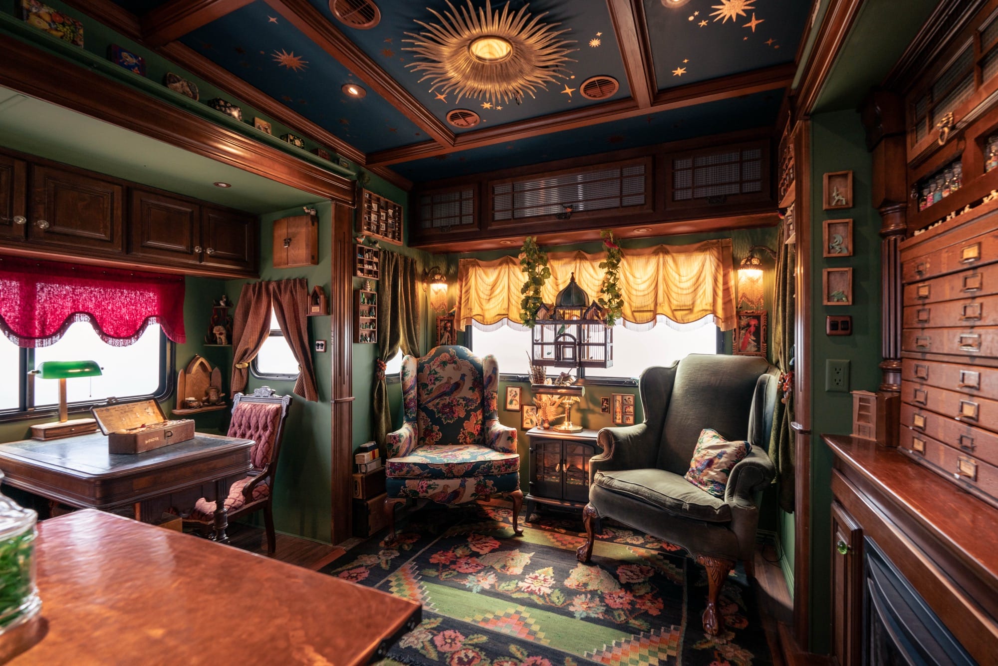 the moody wood and soft seating interior of a traveling museum with cabinets, jars, and lots of storage
