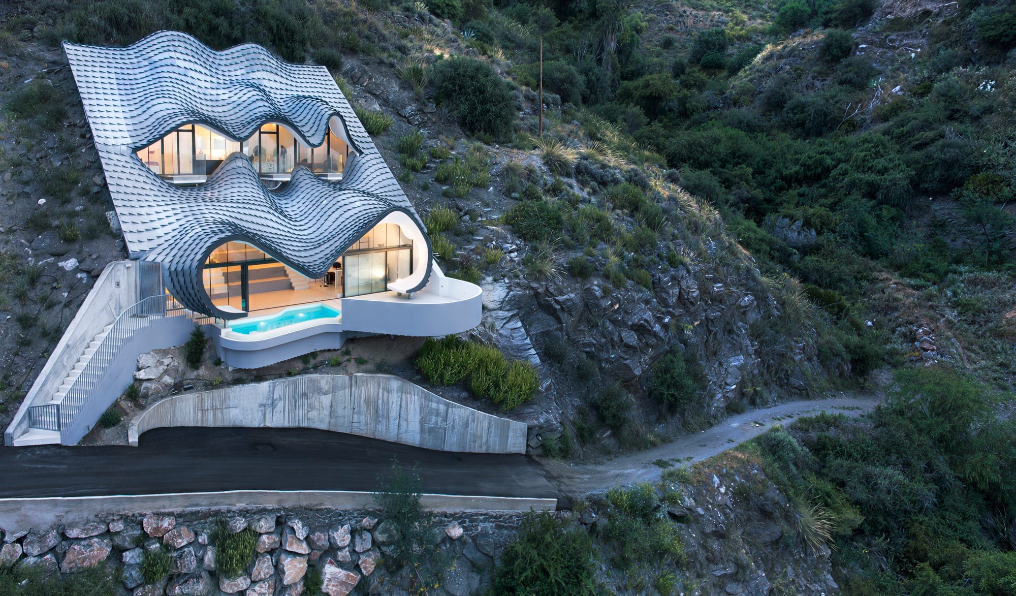 a contemporary home on a steep cliff with undulating windows