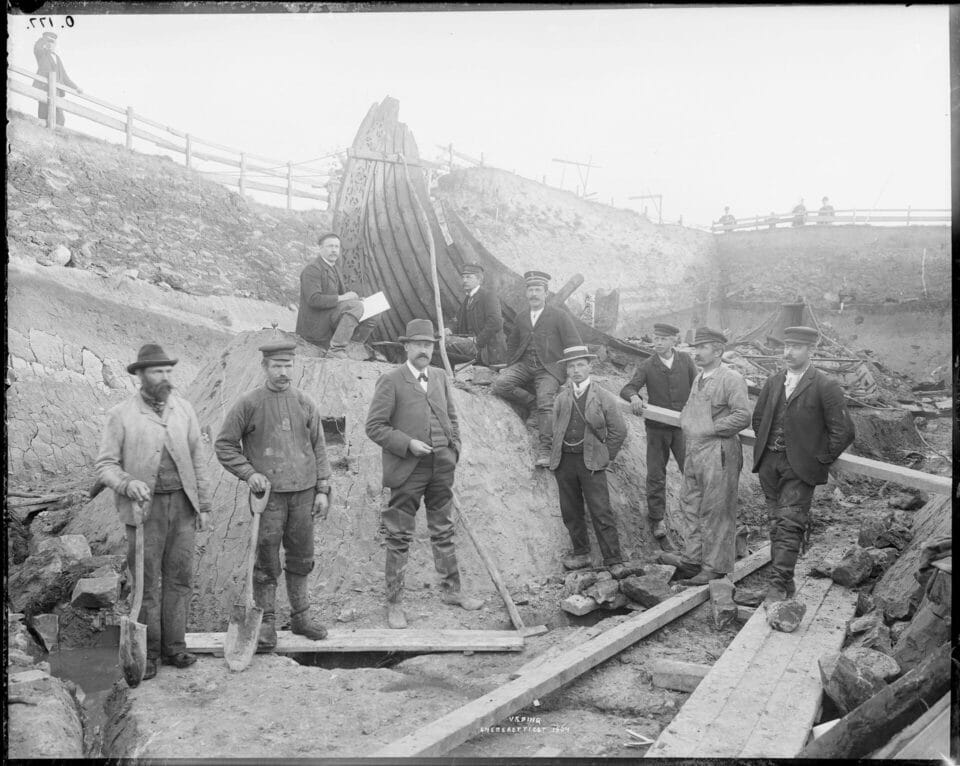 a photograph from 1904 of archaeologists standing in front of the excavated Oseberg Viking Ship