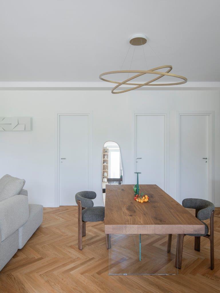 Milan apartment from Gabriela Casagrande modern dining table wood top glass leg