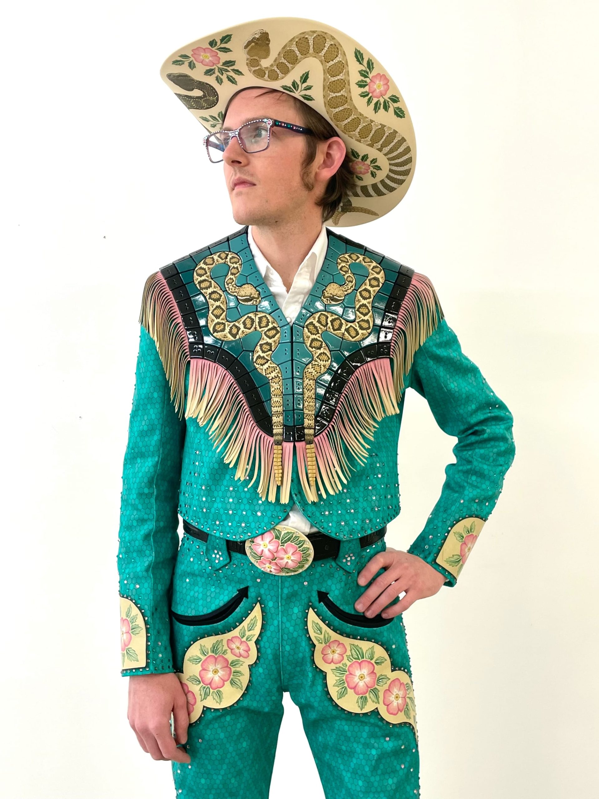 Shae Bishop wears a fringed suit and cowboy hat with elaborate tiles featuring snakes and fringe