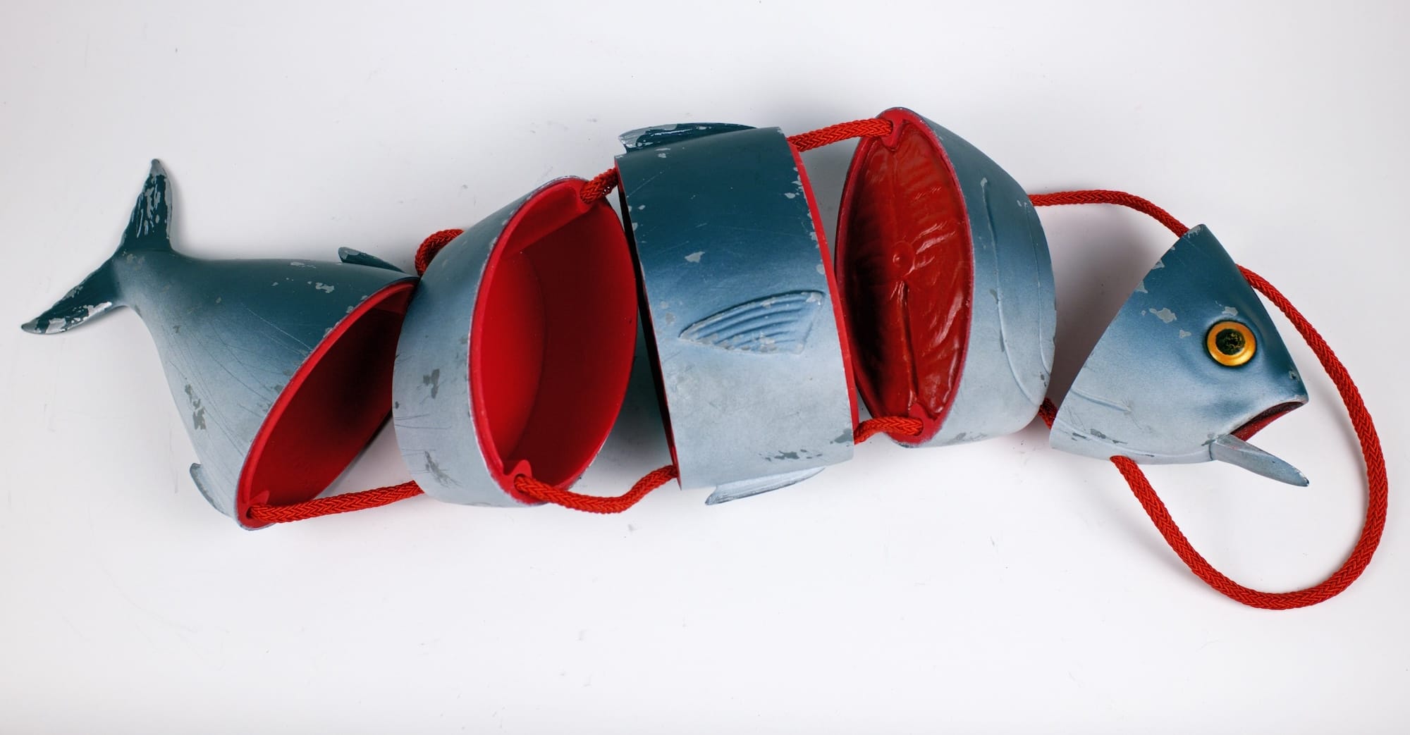 a sculptural purse designed by Paolo Puck in the shape of a fish that comes apart as if it's been chopped into segments