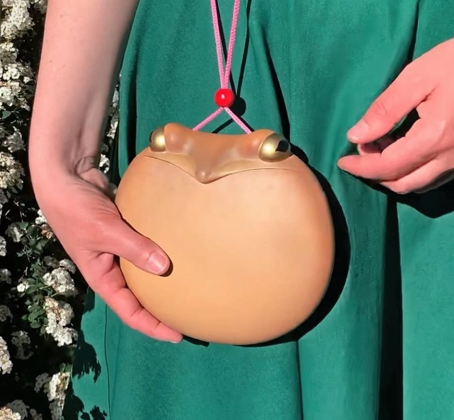 a small purse by Paolo Puck shaped like a round toad