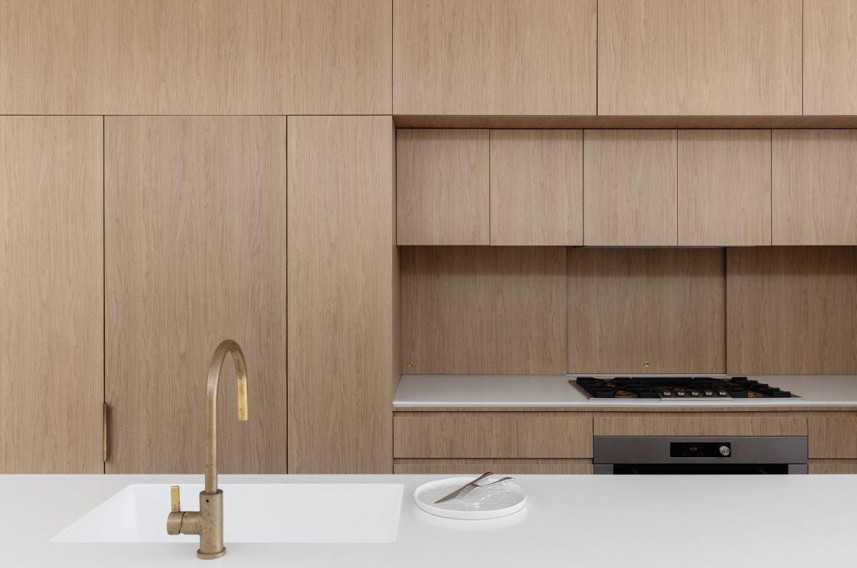 House Is a Playful Dance of Curves kitchen layout brass faucet