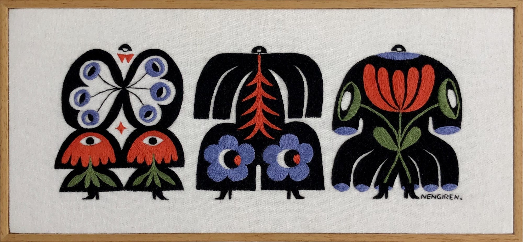 an embroidered artwork by Irene Saputra of three colorful, patterned, symmetrical, abstractly shaped figures