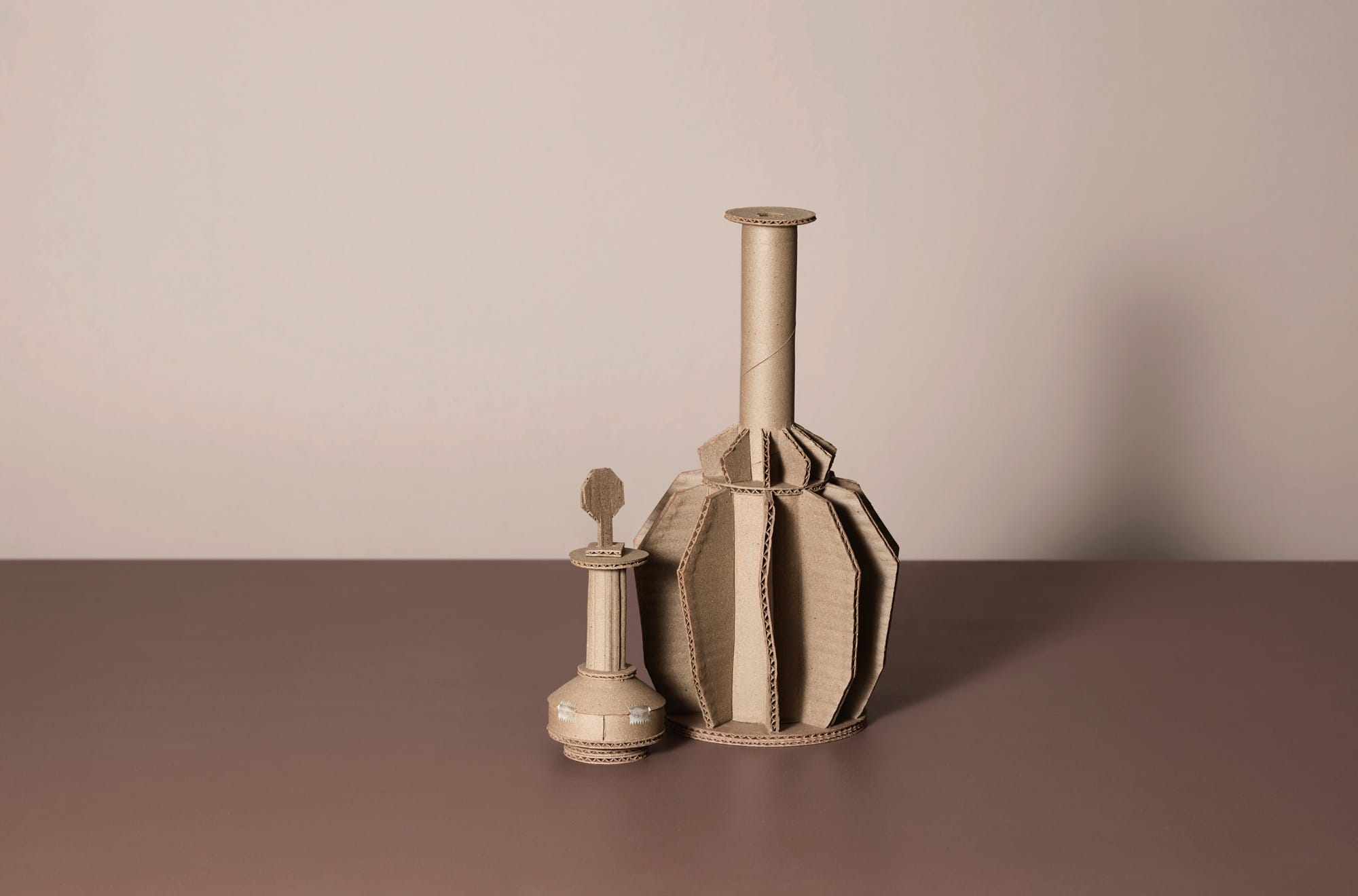 two ceramic vessels by Jacques Monneraud that resemble cardboard with tape, arranged to mimic a painting by Giorgio Morandi